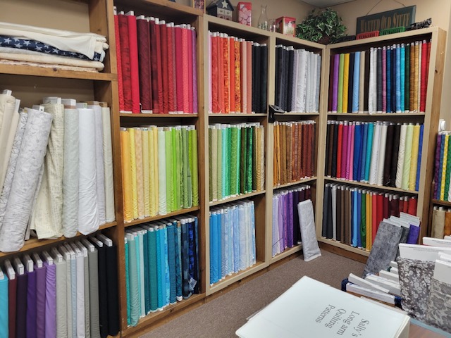 Rainbow of fabrics on shelves