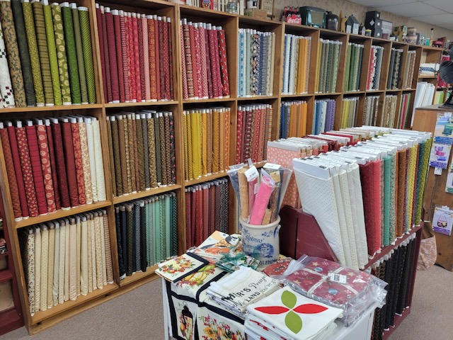 Shelves of fabrics by Kim Diehl and reproduction Civil war fabrics